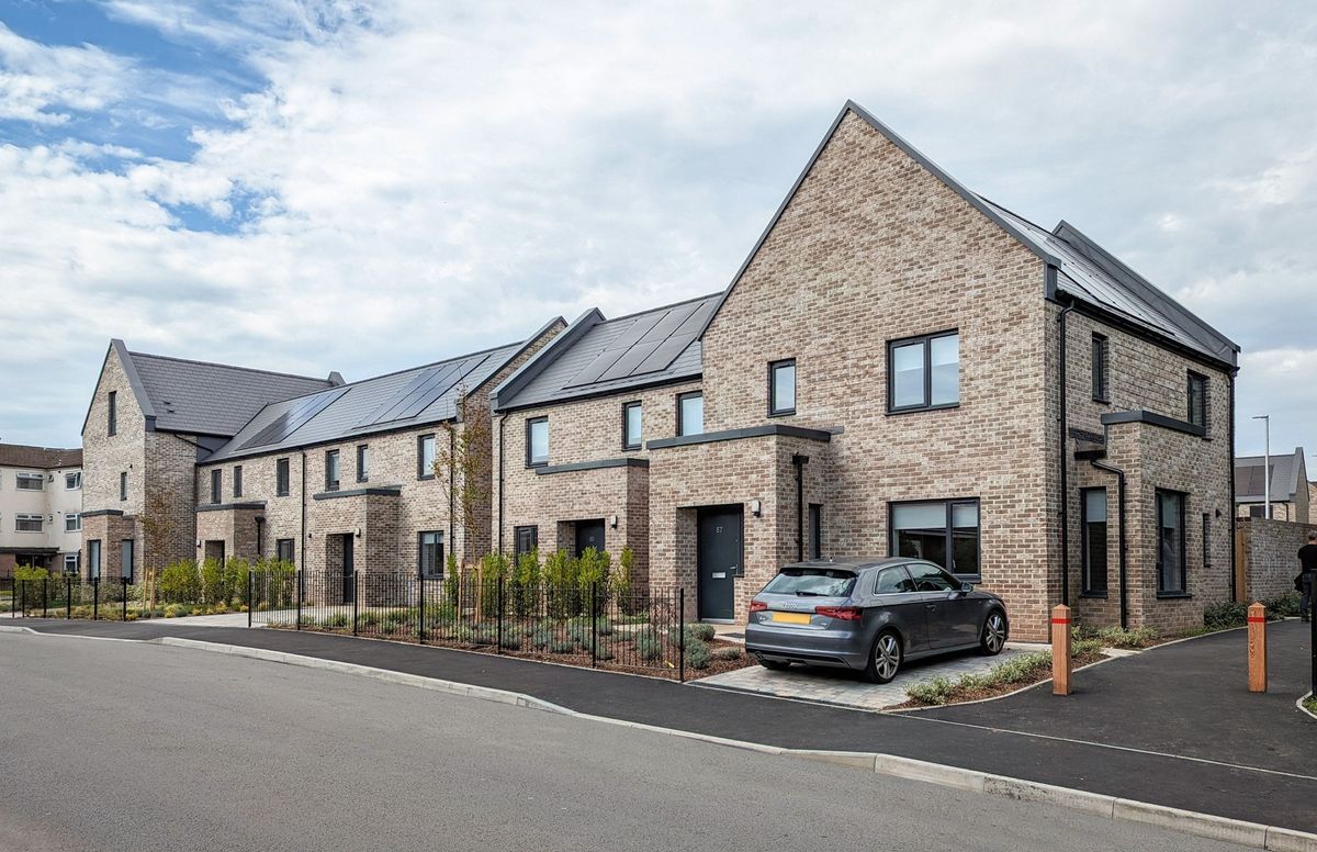 A terrace row of light brown brick houses as part of the Iorwerth Jones development for Cardiff County Council
