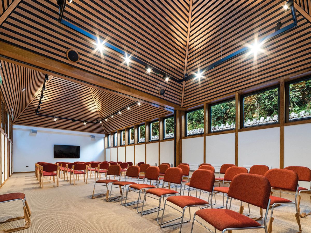 The project included designing meeting spaces and areas dedicated to spiritual guidance and this is inside one filled with chairs in rows at  St Beuno's Jesuit Spirituality Centre, East Wing by Chambers Conservation Limited one of Six projects shortlisted for RSAW Welsh Architecture Awards 2026