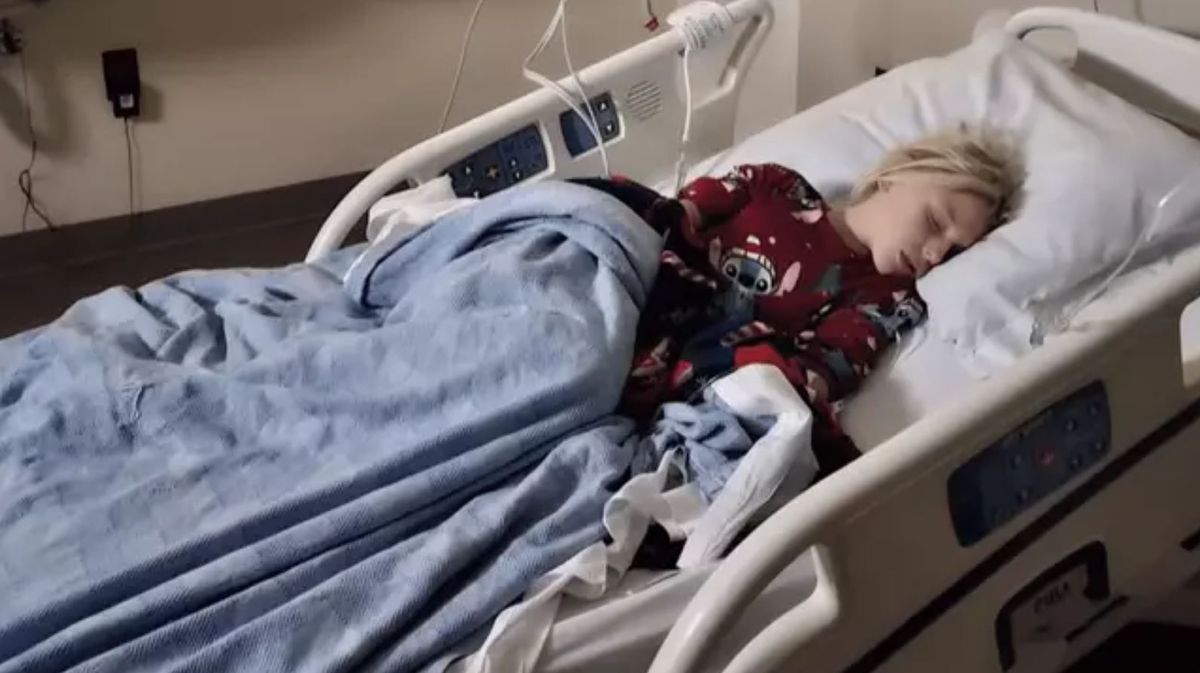 A girl on a hospital bed attached to an IV