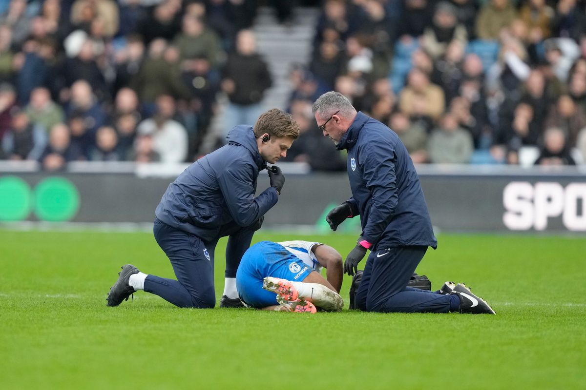 Portsmouth midfielder Ebou Adams lies injured and receives treatment during the EFL Sky Bet Championship match between Millwall and Portsmouth at The Den.