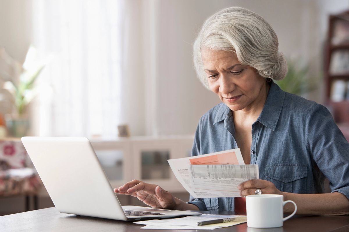 Older Black woman paying bills on laptop
