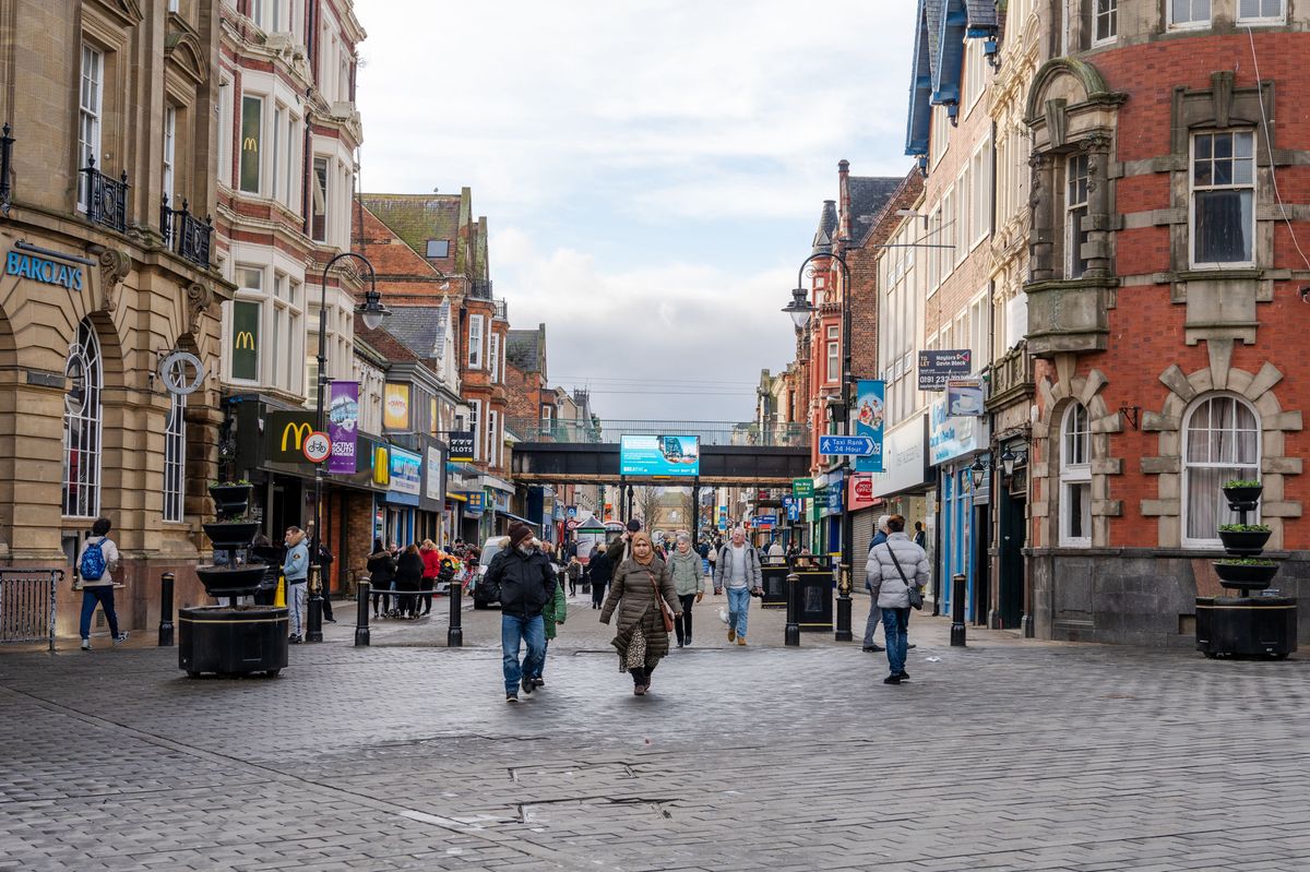  People shopping in South Shields, UK town centre, in winter.