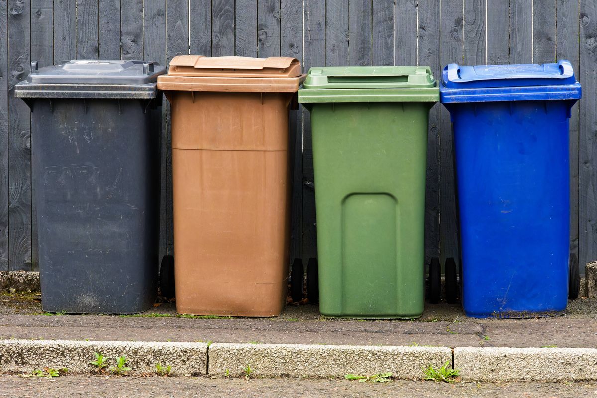 Wheelie bins in row segregated for recycling rubbish UK