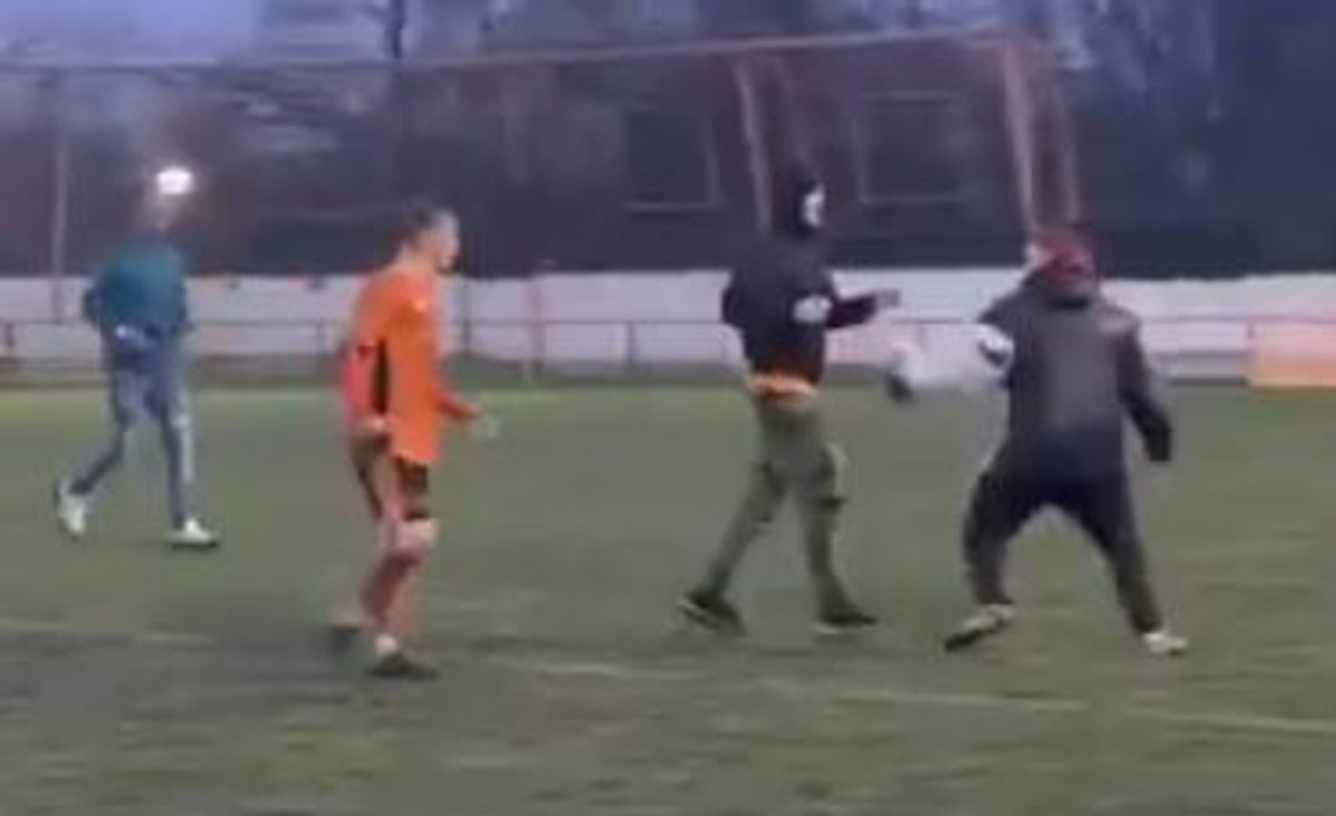 A member of coaching staff appears to throw a punch after being pursued across the pitch