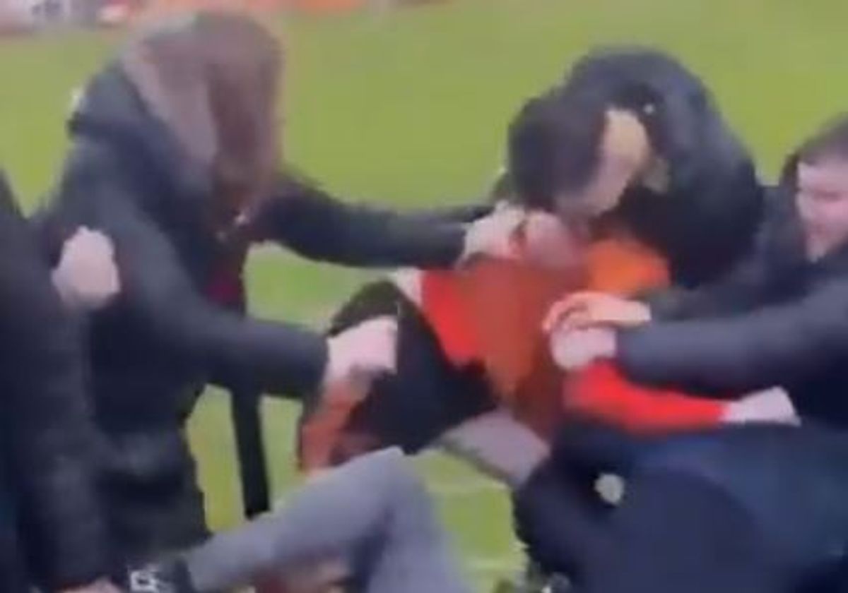 A player fights with supporters during the match between Bilston Town and Droylsden FC