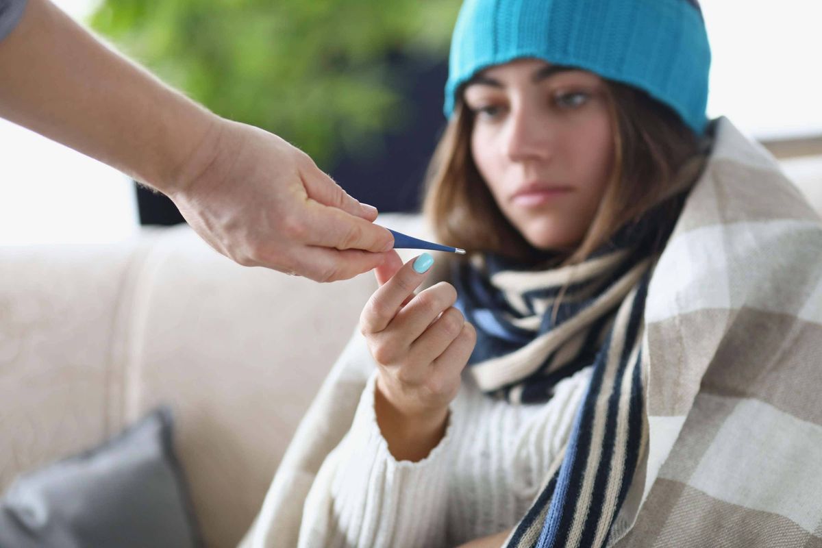 unwell woman with thermometer