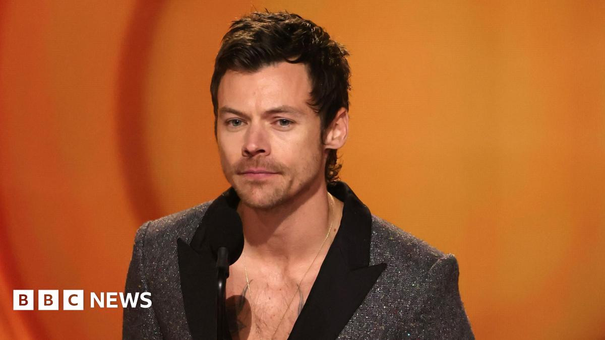 Harry Styles at the Grammys wearing a sparkly grey jacket and black collar