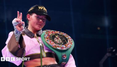 Sandy Ryan with her WBC belt hung over her shoulder with two fingers up to indicated that she had just become a two-weight world champion