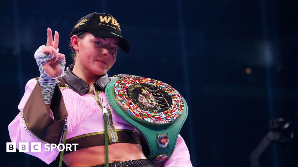 Sandy Ryan with her WBC belt hung over her shoulder with two fingers up to indicated that she had just become a two-weight world champion
