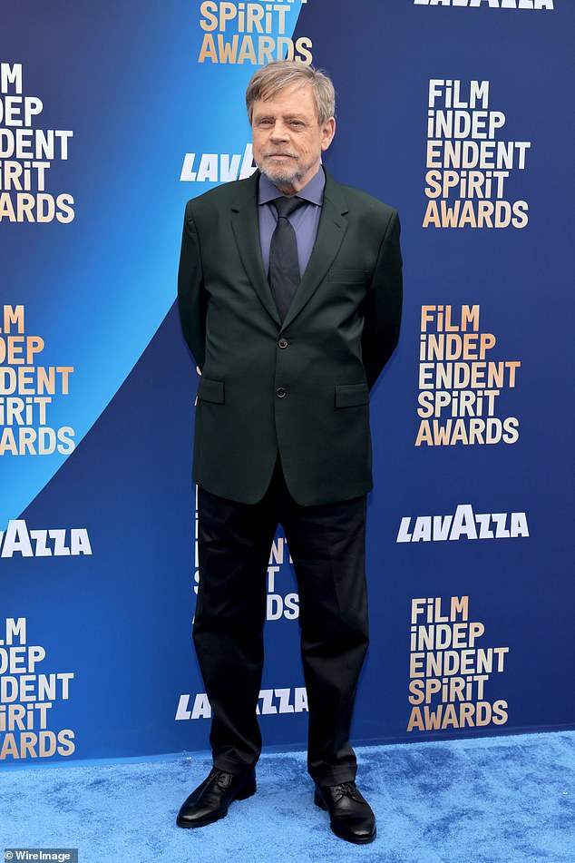 He looked sharp in a dark suit with a purple shirt underneath