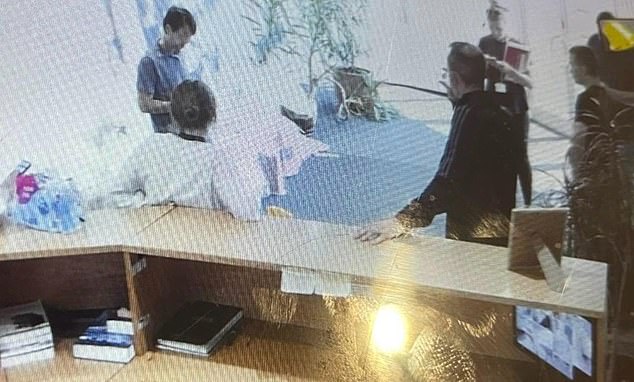 Plain-clothes officers from City of London Police in the lobby of Mr Khan's block of flats in July 2025