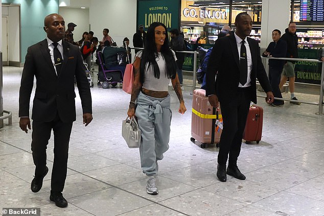 Katie, 47, was flanked by two members of staff who helped her with her luggage