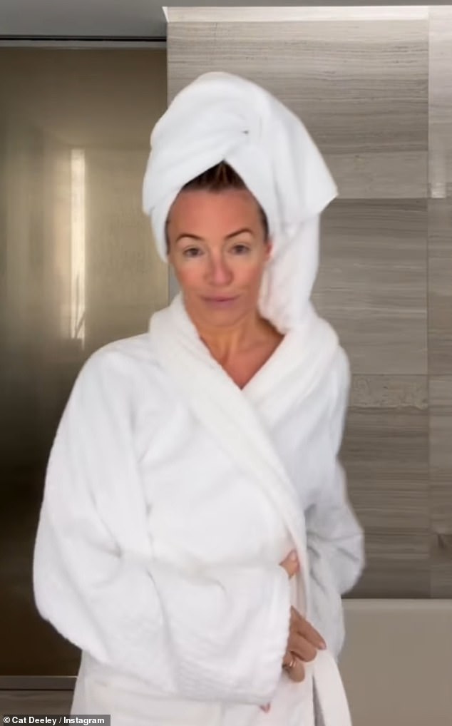 Cat then slipped into a white bathrobe before brushing her hair, putting on her deodorant, and eye drops