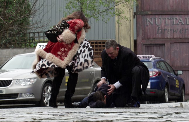 George and Christina crouching over a collapsed Todd in Coronation Street