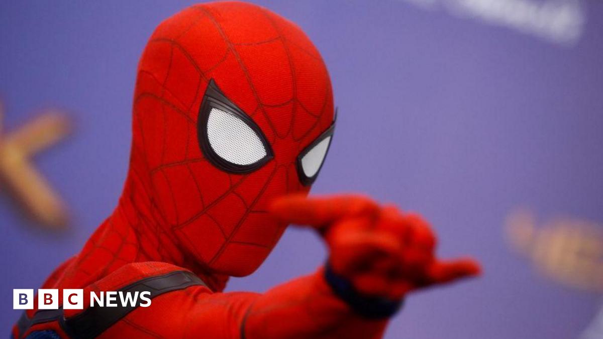 A man dressed as Marvel comics hero Spider-Man poses for photos at a press event