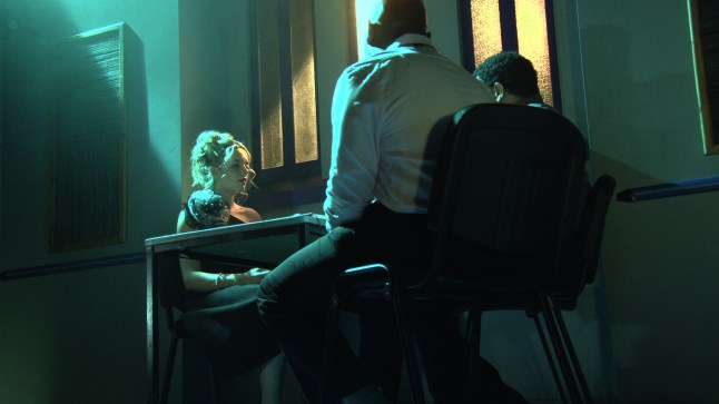 Betsy is questioned by police under green lights in Corrie