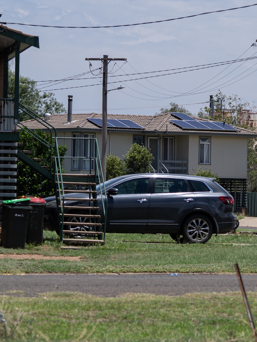 A house with play equipment in the garden and solar cells on the roof