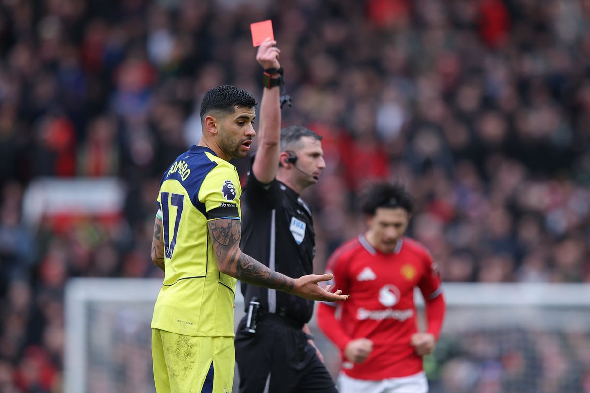 Cristian Romero of Tottenham Hotspur reacts as he is shown a red card by referee Michael Oliver during the Premier League match between Manchester United and Tottenham Hotspur