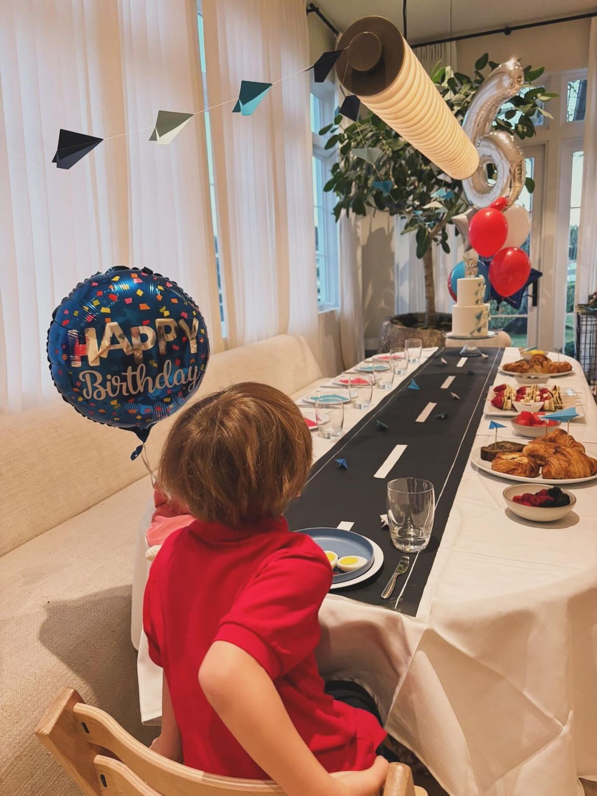 A boy looks across a dining table