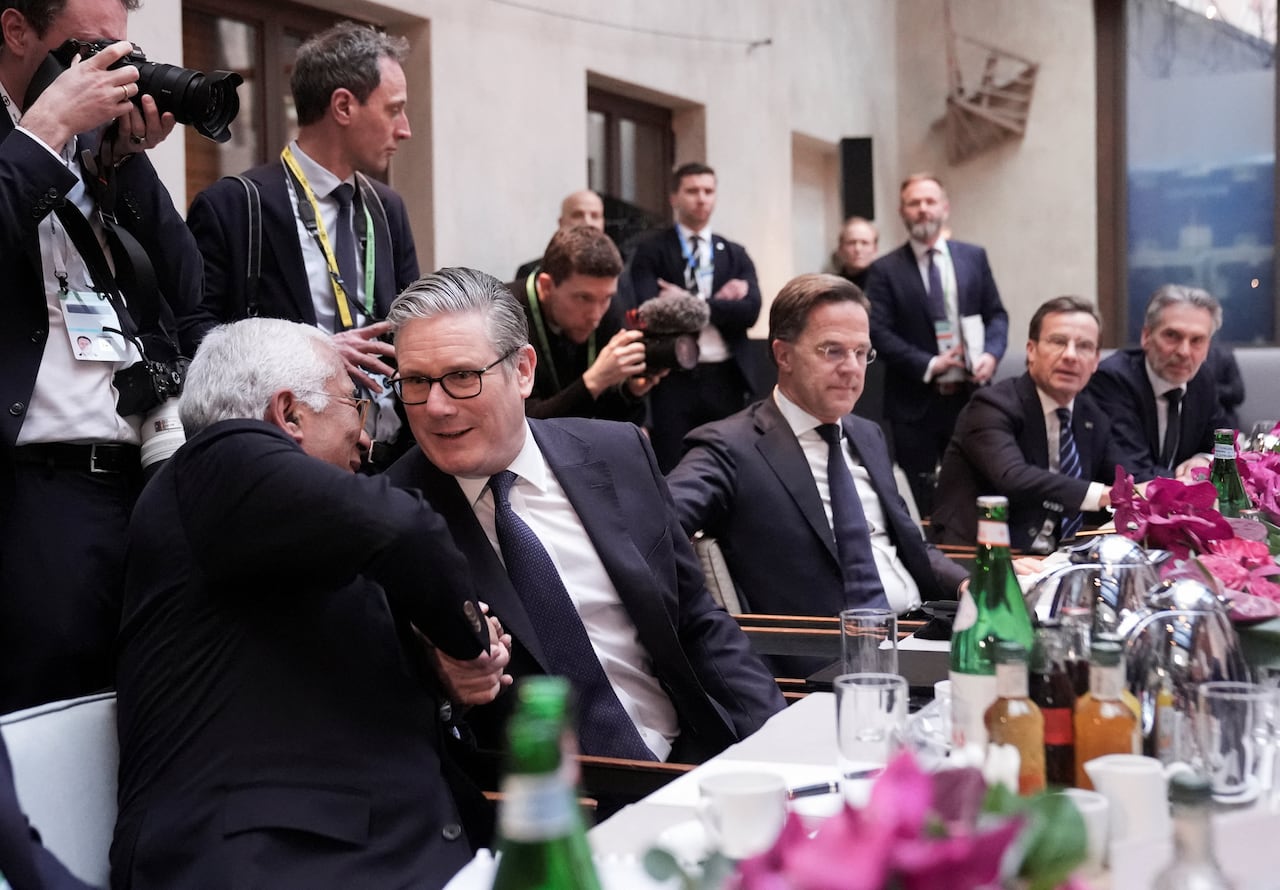 Men shake hands at a long table.