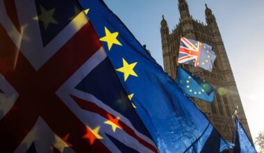 UK-EU Brexit negotiations meeting with officials discussing trade agreements and policy impacts in a formal conference room