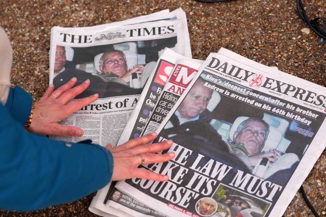 A journalist looks at Friday's newspaper front pages in London after Andrew Mountbatten-Windsor was arrested and held for hours by British police on suspicion of misconduct in public office related to his links to Jeffrey Epstein.