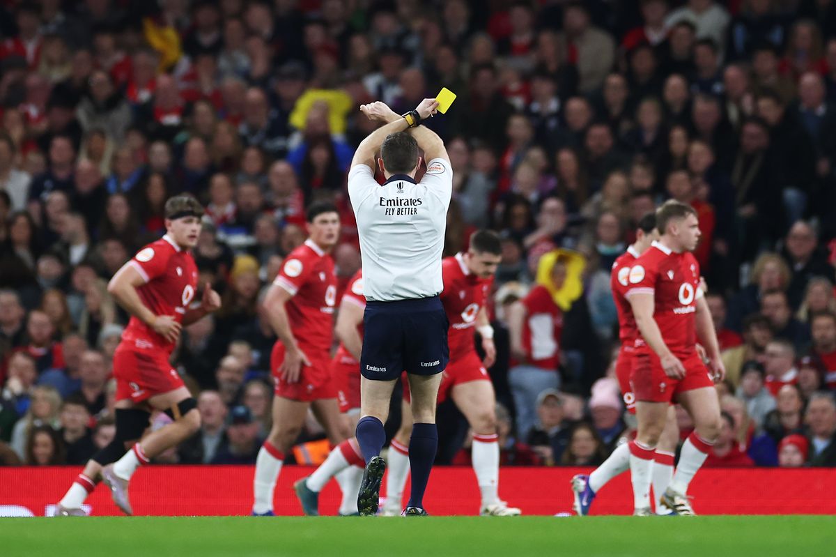 Referee Matthew Carley shows a yellow card to Joe Hawkins