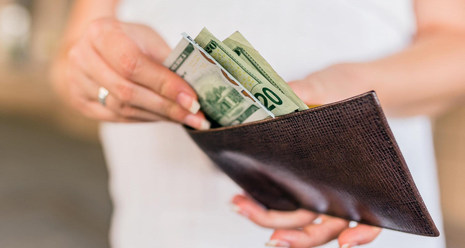 People, business, finances and money concept - close up of businesswoman hands holding open wallet with dollar cash.
