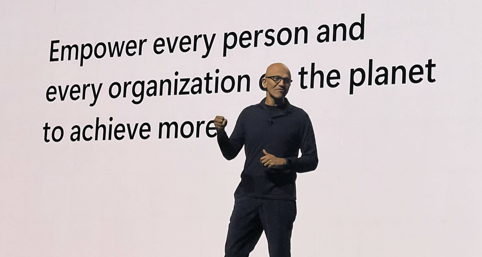 Satya Nadella in front of a white screen delivering the keynote for Microsoft