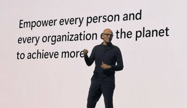 Satya Nadella in front of a white screen delivering the keynote for Microsoft