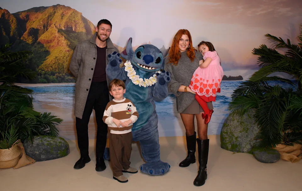 Tommy Andrews and Ashley James with their family meet Stitch at a performance of Disney On Ice.