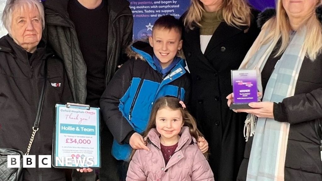 A group of people under a purple tent.