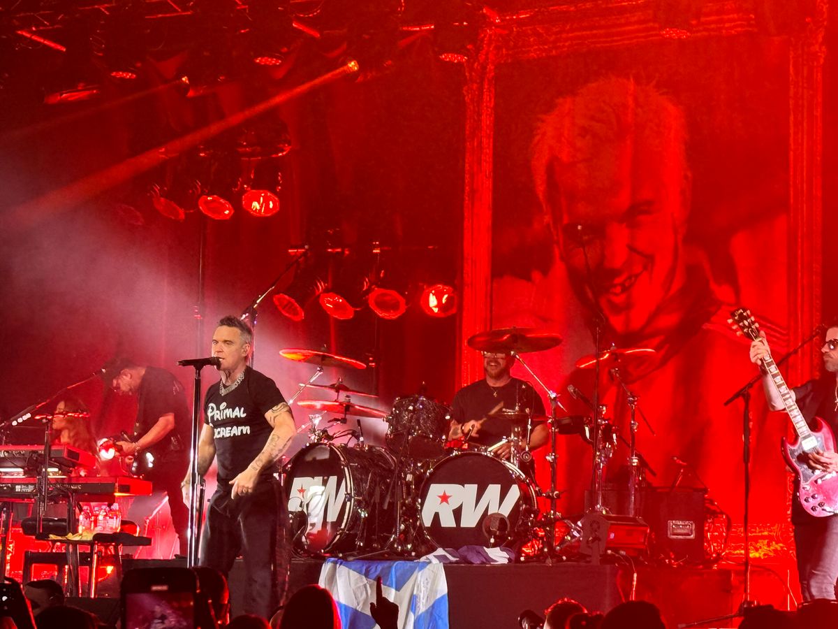 Robbie Williams on stage performing