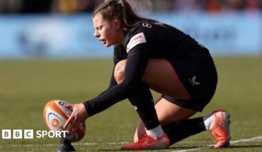 Zoe Harrison putting the ball on the tee