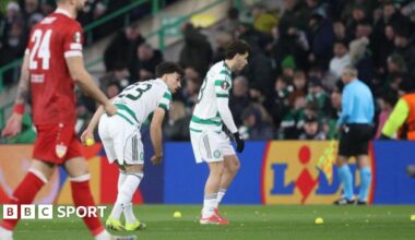 Celtic players pick up tennis balls off the pitch