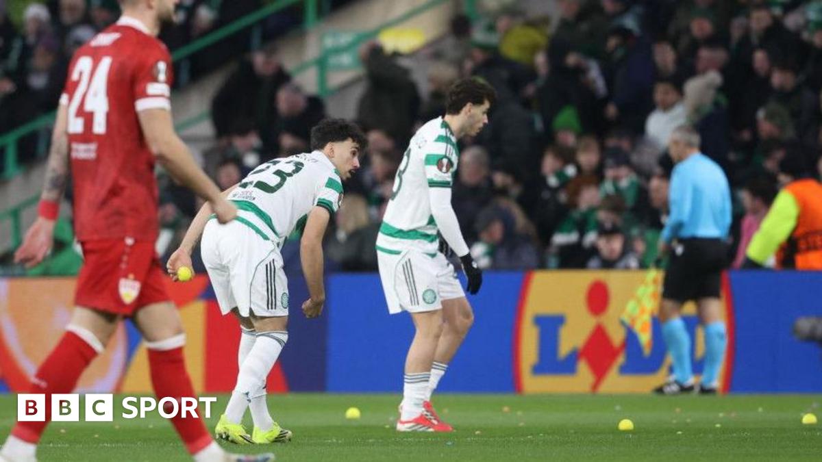 Celtic players pick up tennis balls off the pitch