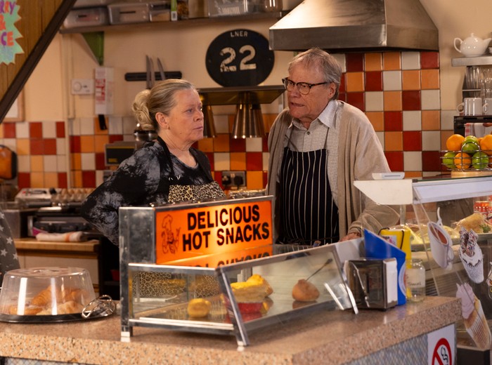 Roy and Bernie chat behind the counter of the cafe in Coronation Street