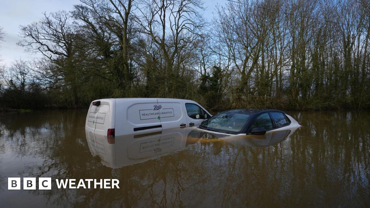 A van and a car left abandoned in a flooded ford in Watery Gate Lane, Thurlaston, Leicestershire. The water rises to the vehicles' front windows.