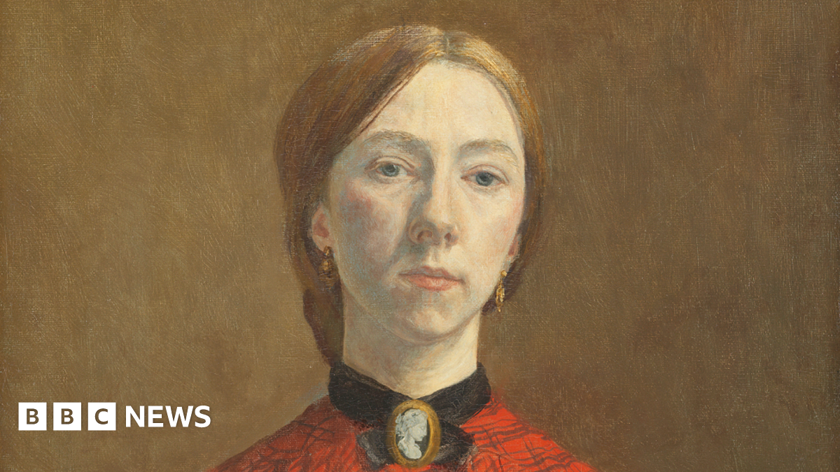 Oil painting of Gwen John. She is a white woman in her twenties. She has light red-brown hair pulled back into a low knot or bun at the back of her head. She is wearing an orange-red blouse with a check pattern on it. at her throat she is wearing a cameo broach with a black ribbon or collar around her throat. The clothing is consistent with the early 1900s. A black shawl is draped over her lower right arm.