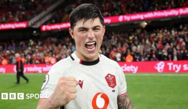 Louis Rees-Zammit pumps his fist in celebration for Wales while standing on the pitch