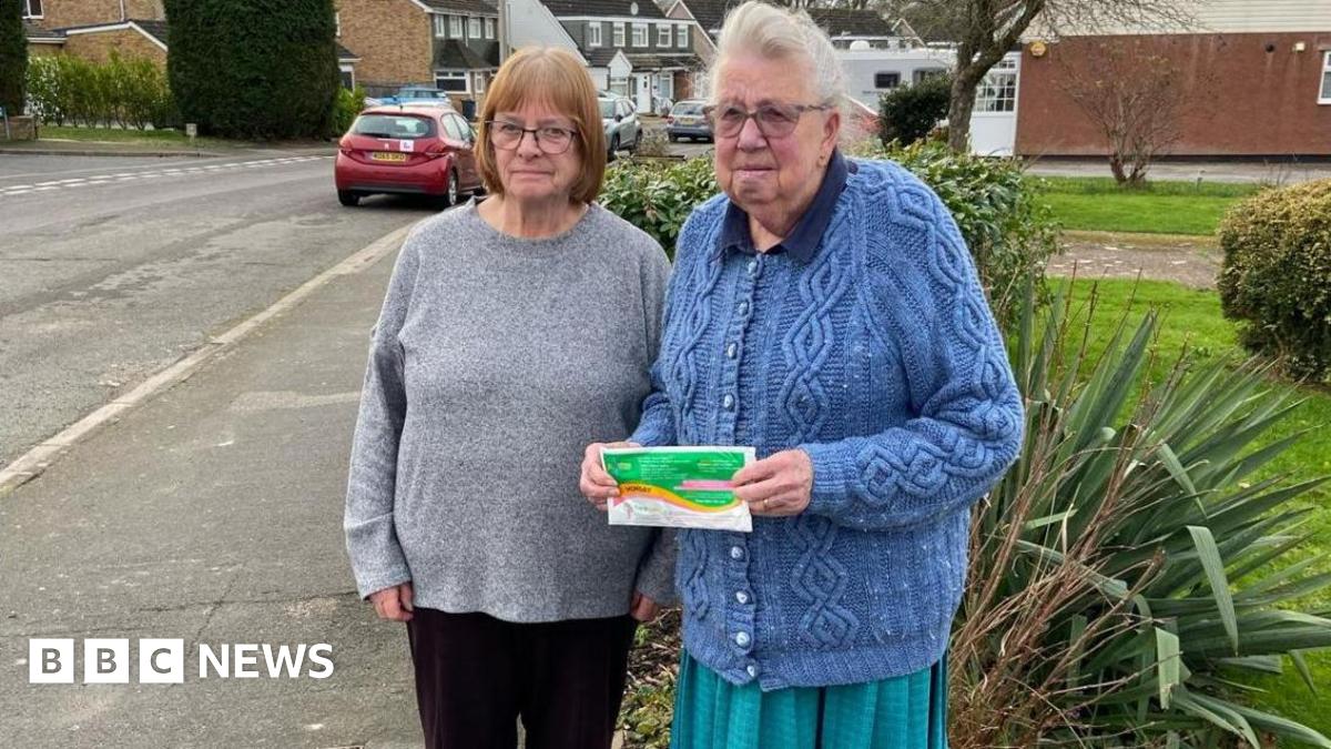 Two elderly women. They are outside their house.