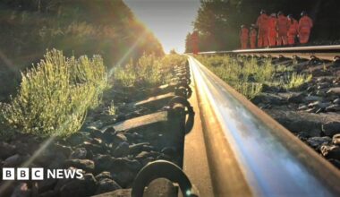 Stock image of a railway track with workers wearing hi-vis jackets