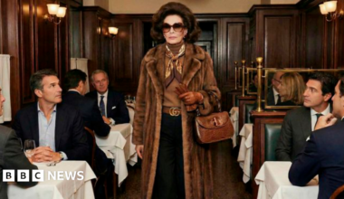 AI Generated images from Gucci - a woman in a fur coat, two young people on a car bonnet wearing vests and sunglasses, a large retro white car, a glamourous couple in black tie sitting in a formal living room looking atthecamera