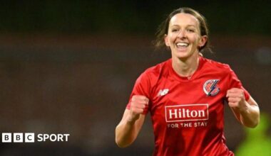 Kate Cross celebrates taking a wicket for Lancashire, wearing red kit