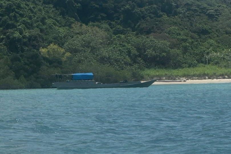 A small fishing boat off the coast of a tropical island