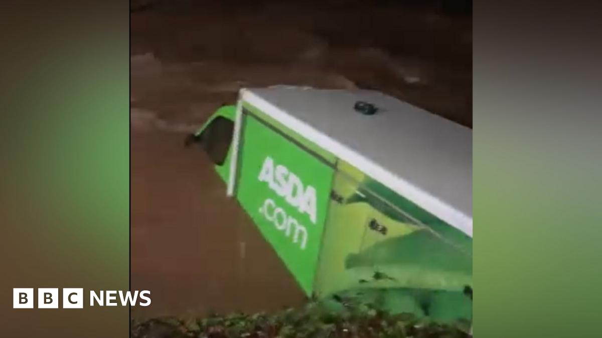 An aerial image shows a flooded road surrounded by standing water in a rural setting with trees, greenery and more floodwater in the background, in Hampshire on Friday.