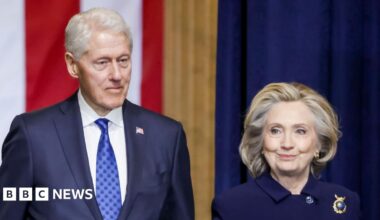 Former President Bill Clinton lays in a hot tub. Sitting next to him is a person whose face has been redacted