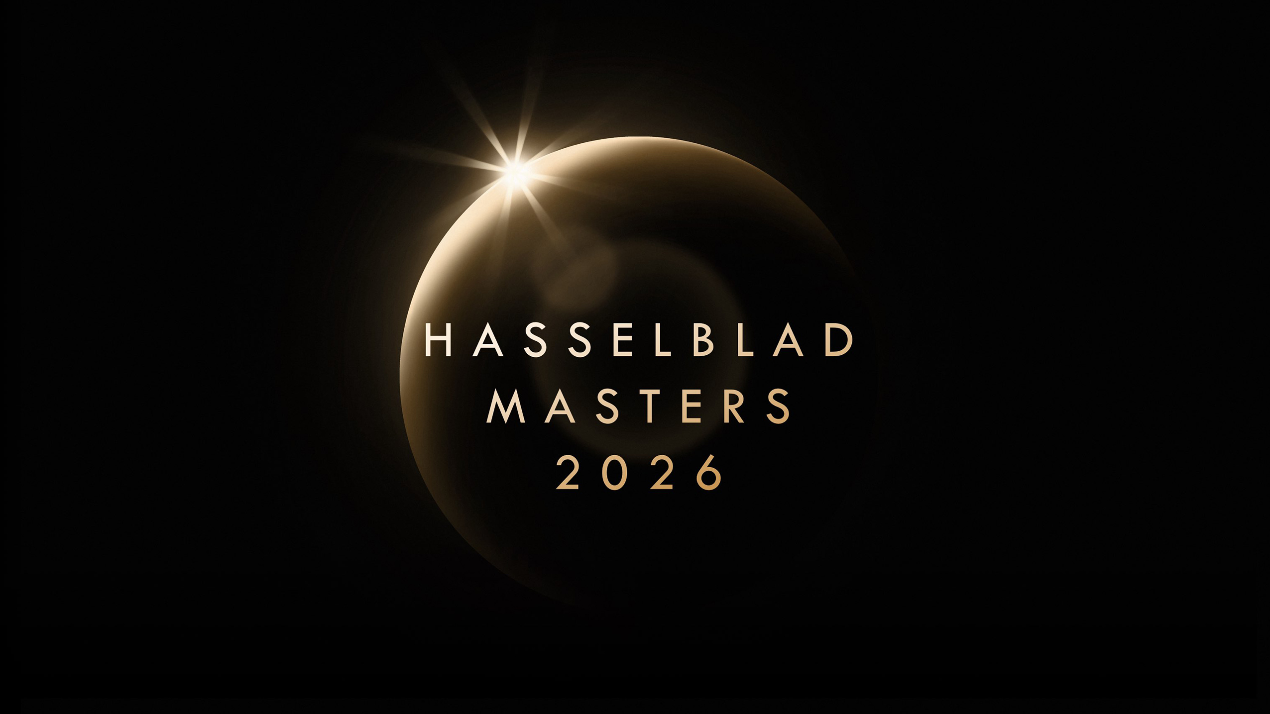 Logo for Hasselblad Masters 2026 featuring elegant, golden text against a dark background, with a lens flare effect on a circular shape