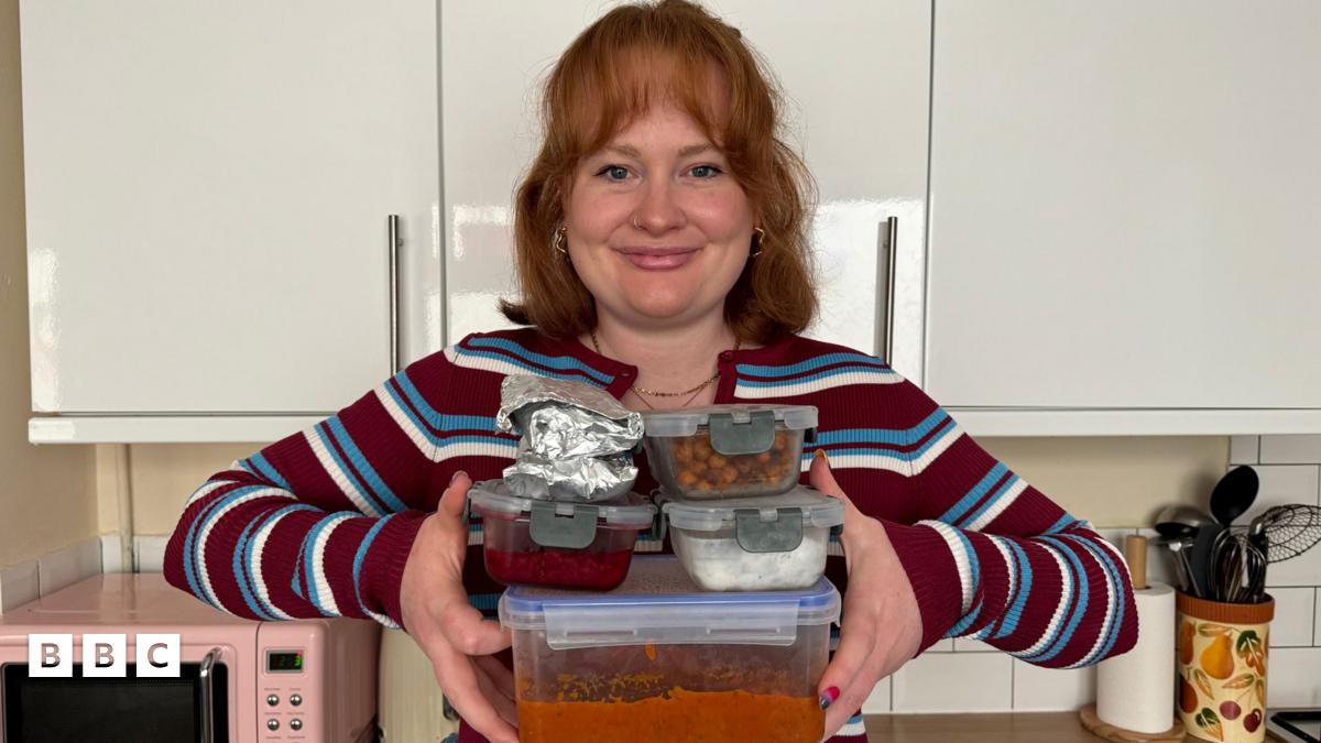 Izzie Cox holding four filled food containers and two breakfast wraps which are in foil