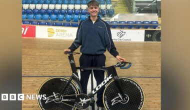 Lewis stood on the Derby Arena velodrome track with his racing bike.